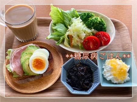 《糖尿病ごはん》全粒粉入りパンのオープンサンドと温野菜サラダ、ヨーグルトやモズク酢を並べた朝食。